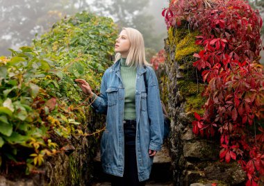 Sonbaharda Virginia sarmaşığıyla bahçede güzel bir sarışın. 