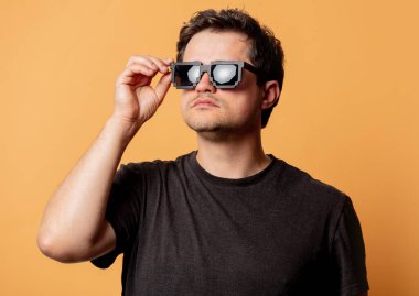 Sarı arka planda güneş gözlüklü adam. 