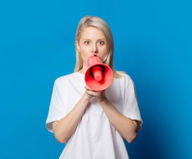 Mavi arka planda megafonu olan beyaz tişörtlü sarışın.