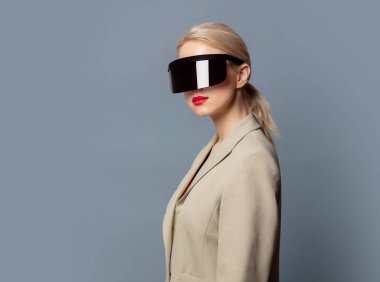 Gri arka planda fütüristik VR gözlüklü tarz sarışın