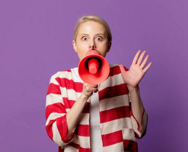 Kırmızı ceketli güzel bir sarışındı. Saflık arka planında megafon vardı.