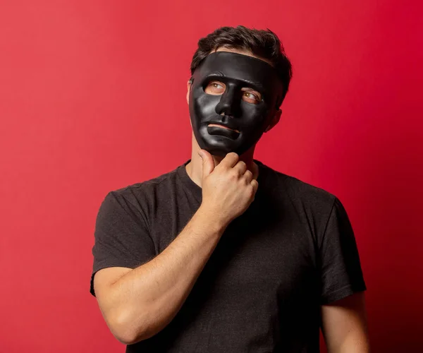 Hombre Blanco Máscara Negra Sobre Fondo Rojo —  Fotos de Stock