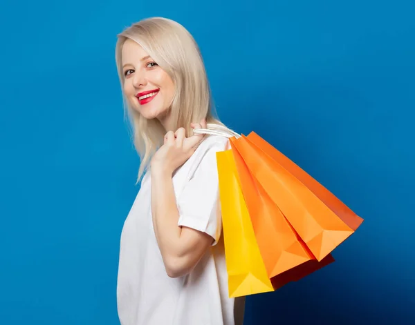 Rubia Camiseta Blanca Con Bolsas Compras Sobre Fondo Azul — Foto de Stock