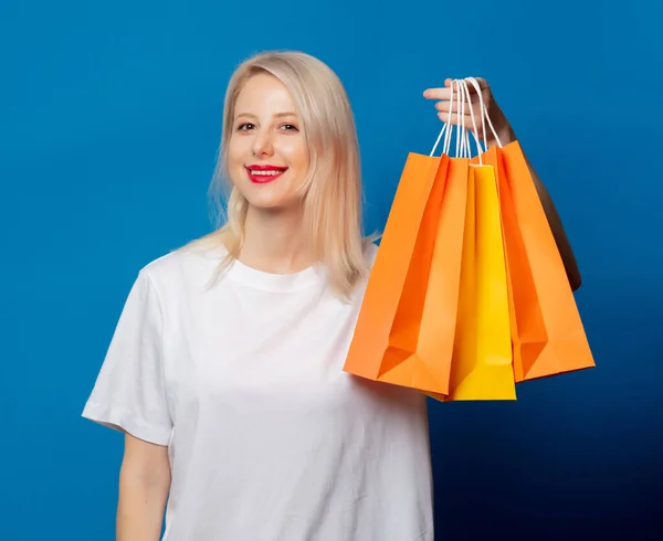 Rubia Camiseta Blanca Con Bolsas Compras Sobre Fondo Azul —  Fotos de Stock