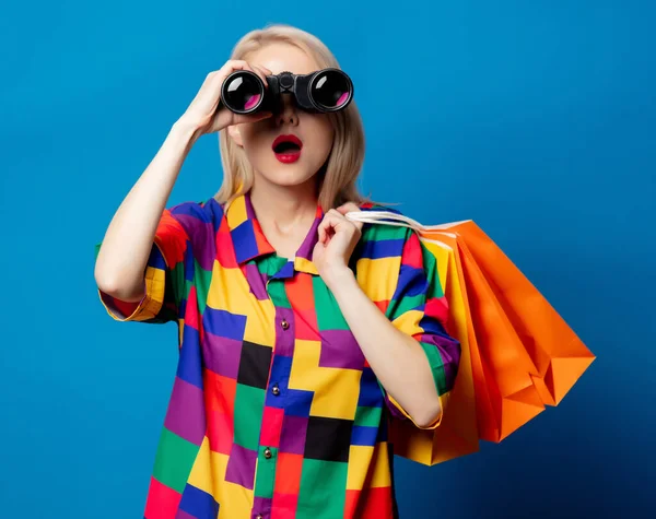 Blond Meisje Jaren Shirt Met Verrekijker Boodschappentassen Blauwe Achtergrond — Stockfoto