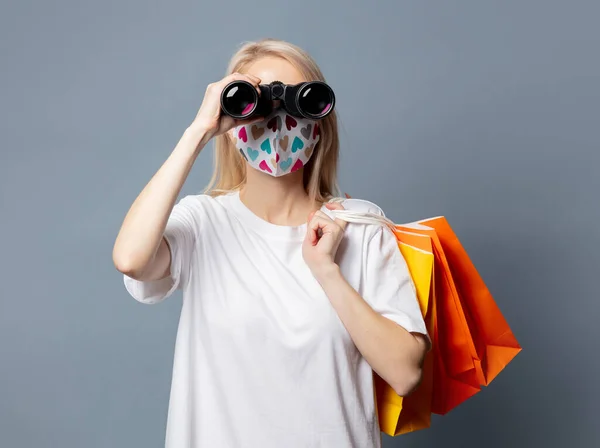 Beautiful Girl Face Mask Shopping Bags Binoculars Grey Background — Stock Photo, Image