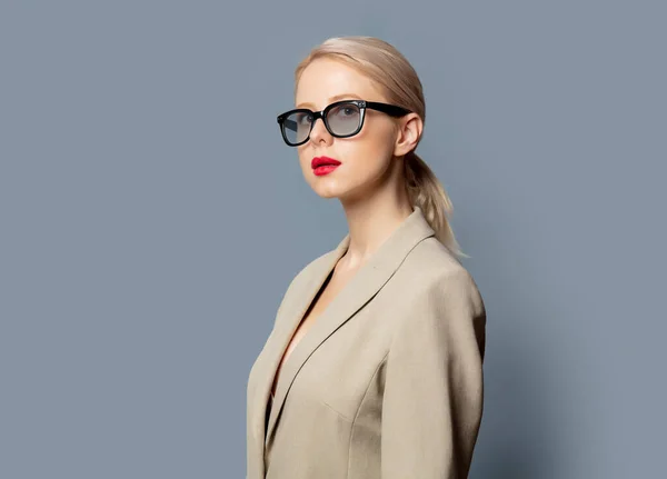 Mujer Rubia Chaqueta Gafas Sobre Fondo Gris —  Fotos de Stock