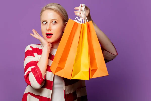 Schöne Blondine Roter Jacke Mit Einkaufstaschen Auf Puprle Hintergrund — Stockfoto