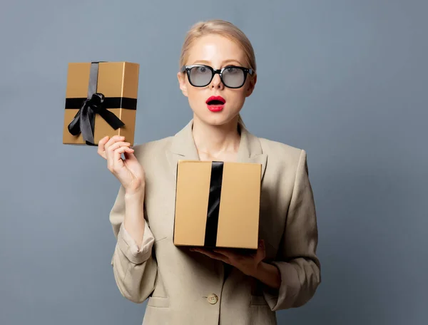 Style Blonde Jacket Glasses Holds Gift Box Gray Background — Stock Photo, Image