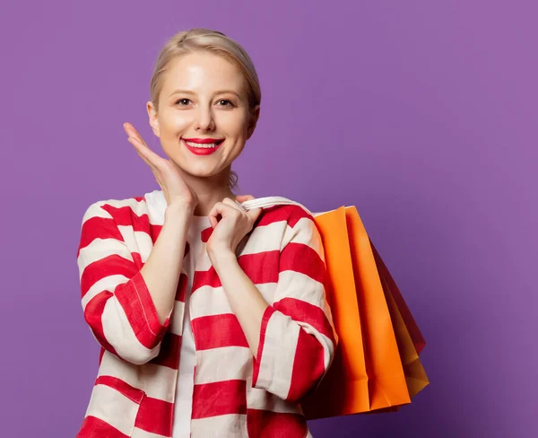 Hermosa Rubia Chaqueta Roja Con Bolsas Compras Sobre Fondo Puprle —  Fotos de Stock