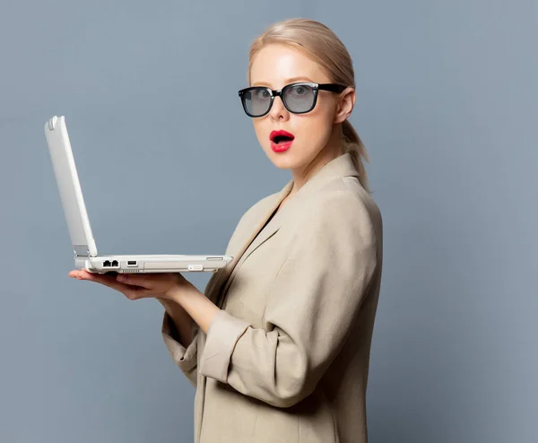 Style blonde with laptop computer on gray background