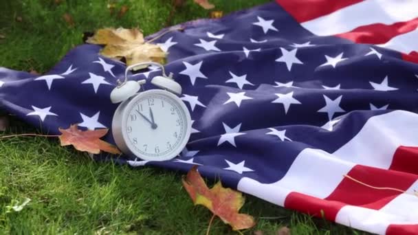 Amerikanische Flagge Mit Ahornblättern Und Wecker Auf Grünem Gras Herbst — Stockvideo