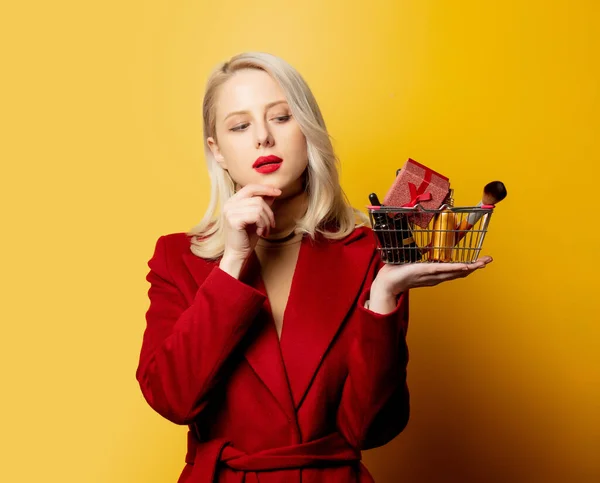 Mooie Vrouw Rode Jas Met Mand Vol Cosmetica Gele Achtergrond — Stockfoto