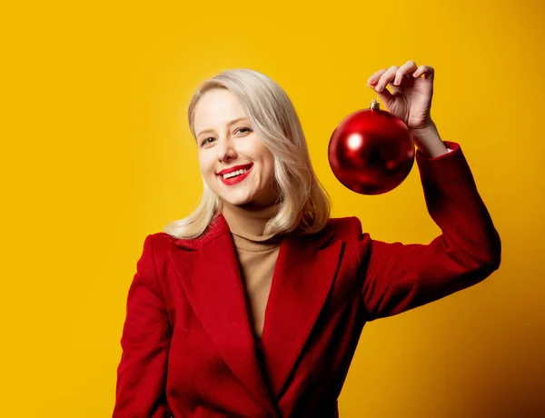 Sarışın Kırmızı Ceketli Sarı Arka Planda Noel Mücevherli Bir Kadın — Stok fotoğraf