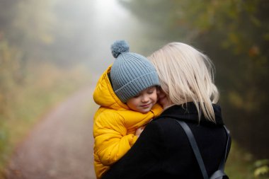 Baba ve oğul, sonbahar ormanlarında sisin içinde eğleniyorlar. Silezya, Polonya