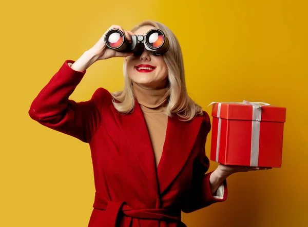 Woman Red Coat Binoculars Gift Box Yellow Background — Stock Photo, Image