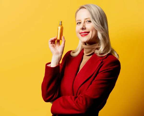Mujer Abrigo Rojo Con Perfume Sobre Fondo Amarillo —  Fotos de Stock