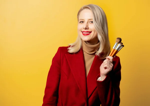 Mooie Vrouw Rode Jas Met Borstels Gele Achtergrond — Stockfoto