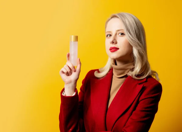 Mulher Casaco Vermelho Com Garrafa Loção Fundo Amarelo — Fotografia de Stock