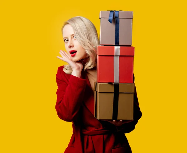 Blonde Woman Red Coat Gift Boxes Yellow Background — Stock Photo, Image