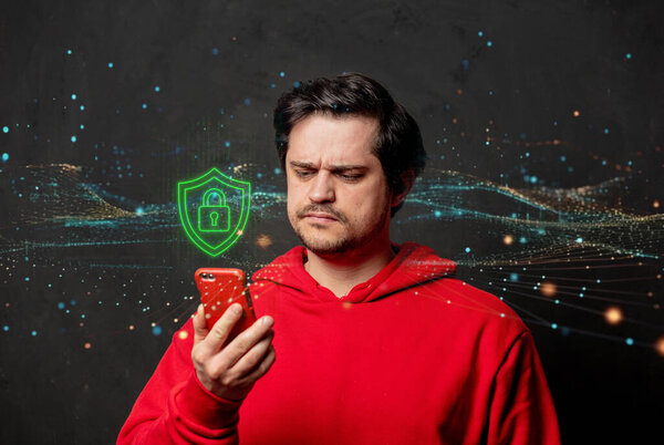 A man is holding a smartphone in his hands against a neutral gray background. On the screen, a glowing cybersecurity lock symbol is displayed, representing online safety and data protection