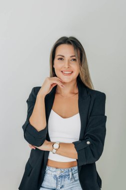 stylish European young woman with long hair stands confidently against a clean white background