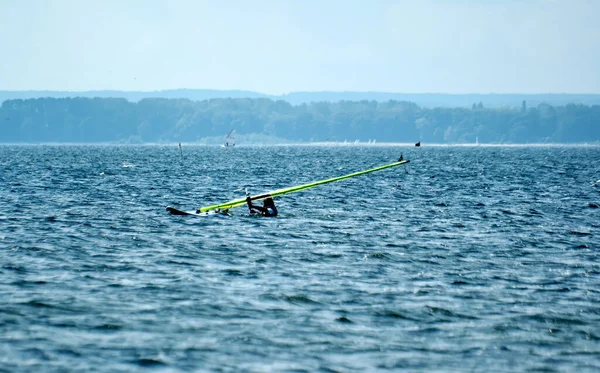 サーファーは夏休みの暖かいポーランドのパック湾でボードで泳いでいます — ストック写真