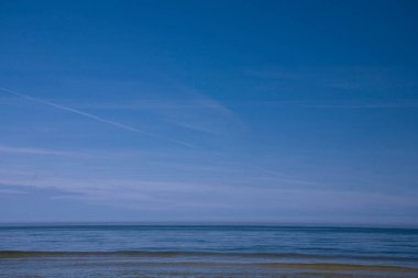 Bulutsuz gökyüzü ve suyla güzel, sakin, mavi deniz manzarası