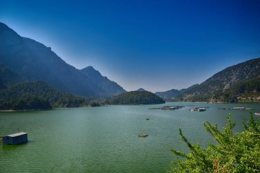 Turki dağlarında güzel, güneşli bir sabah. Yeşil, mavi, büyük, sakin bir gölün üstünde.