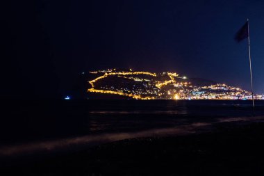 Tepesinde ışıklar olan Türk şehri Alanya 'nın güzel gece manzarası