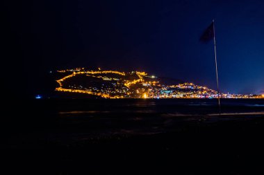 Tepesinde ışıklar olan Türk şehri Alanya 'nın güzel gece manzarası