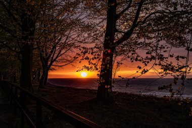 Polonya 'da Baltık Denizi' nin kıyılarında renkli bulutlarla sakin bir gün batımı.
