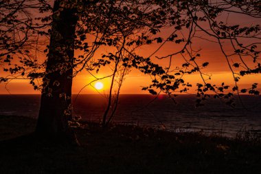 Polonya 'da Baltık Denizi' nin kıyılarında renkli bulutlarla sakin bir gün batımı.