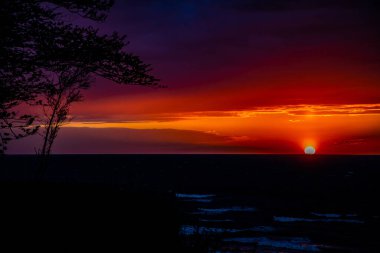 Polonya 'da Baltık Denizi' nin kıyılarında renkli bulutlarla sakin bir gün batımı.