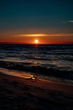 Polonya 'da Baltık Denizi' nin kıyılarında renkli bulutlarla sakin bir gün batımı.