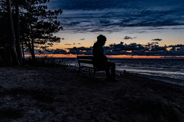 Belo Pôr Sol Colorido Mar Observado Por Homem Boné Sentado — Fotografia de Stock