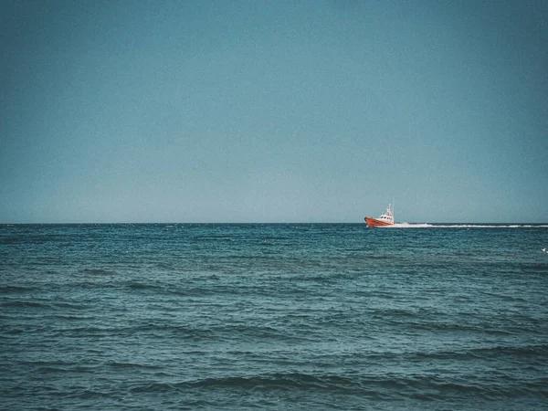 small white and red sea rescue vessel sailing on the Polish Baltic Sea against the blue sky on a warm summer day