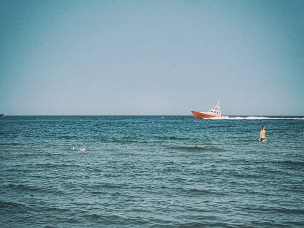 small white and red sea rescue vessel sailing on the Polish Baltic Sea against the blue sky on a warm summer day