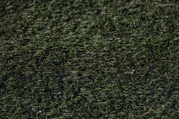 beautiful green background of artificial turf football field in closeup