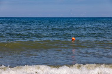 Bir yaz günü mavi Baltık denizinde turuncu şamandıra