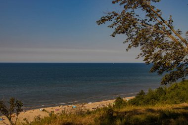 Baltık Denizi 'ndeki yamaçtan sahile insanların dinlendiği bir yaz günü manzarası