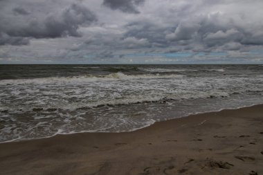 Polonya 'da Baltık Denizi' nde güzel, geniş bir sahil Yazın bulutlu, gri, soğuk bir günde