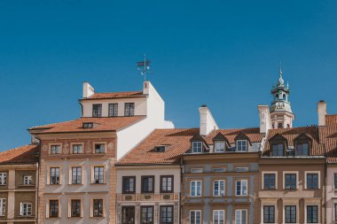 Polonya 'nın Varşova kentindeki eski kasaba meydanında mavi gökyüzüne karşı eski güzel tarihi apartman evleri.
