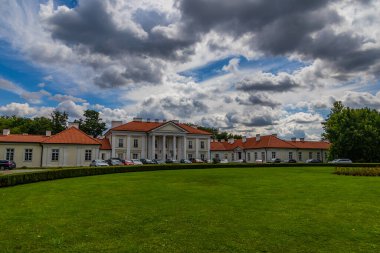 Klasik mimarisi olan büyük bir malikane geniş yeşil çimlerin arasında görkemli bir şekilde duruyor.