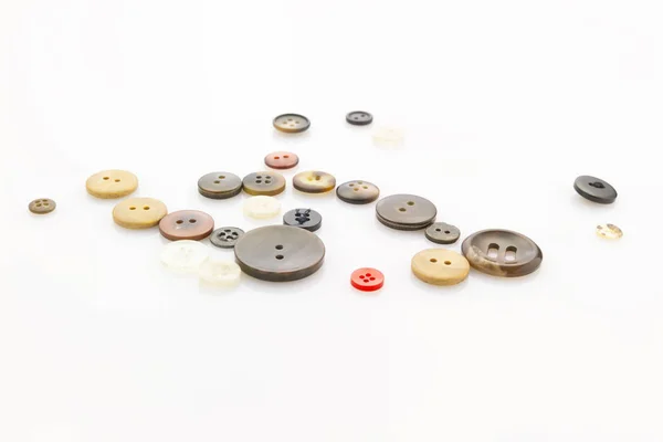 Beyaz Yansıtıcı Arka Plan Üzerinde Döşeme Çeşitli Düğmeleri Topluluğu — Stok fotoğraf
