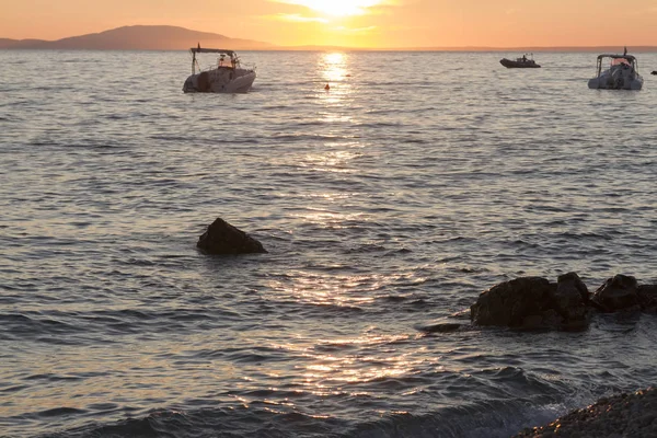 地平線上に海でボートと島の夕景 — ストック写真