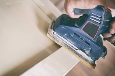 Eski kapıları boyayla zımparalamak ve hazırlamak yeni bir boya yalamak, pürüzsüz zımparalama ya da boya çıkarma konsepti için..