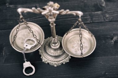 Hukuk ve Adalet, Hukuk kavramı, Adalet terazisi ve siyah ahşap arka planda kelepçeler..