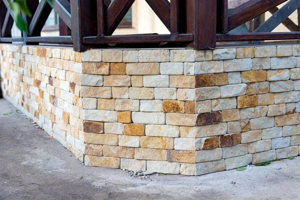 The look of the foundation of the house is covered with a yellow sandstone from the outside