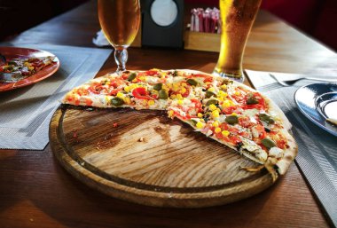 Pizza, bira ve mutfak eşyaları kafede masada gözlük